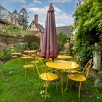 A simple garden with yellow tables and chairs